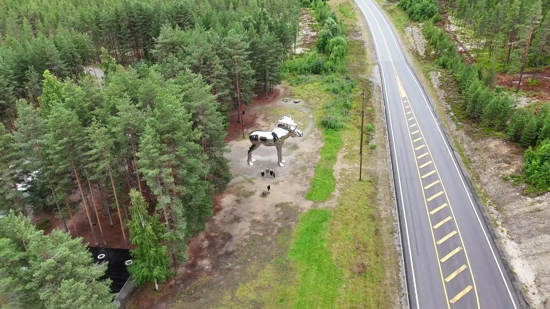 Luftaufnahme einer Elchskulptur an einer Straße im nordischen Wald
